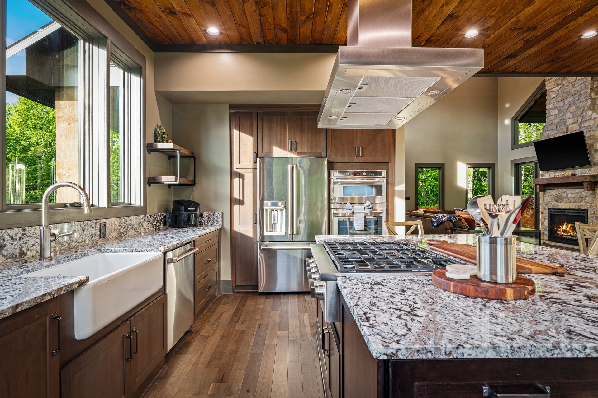 Chef's kitchen with granite island, wood cabinetry and farmhouse sink