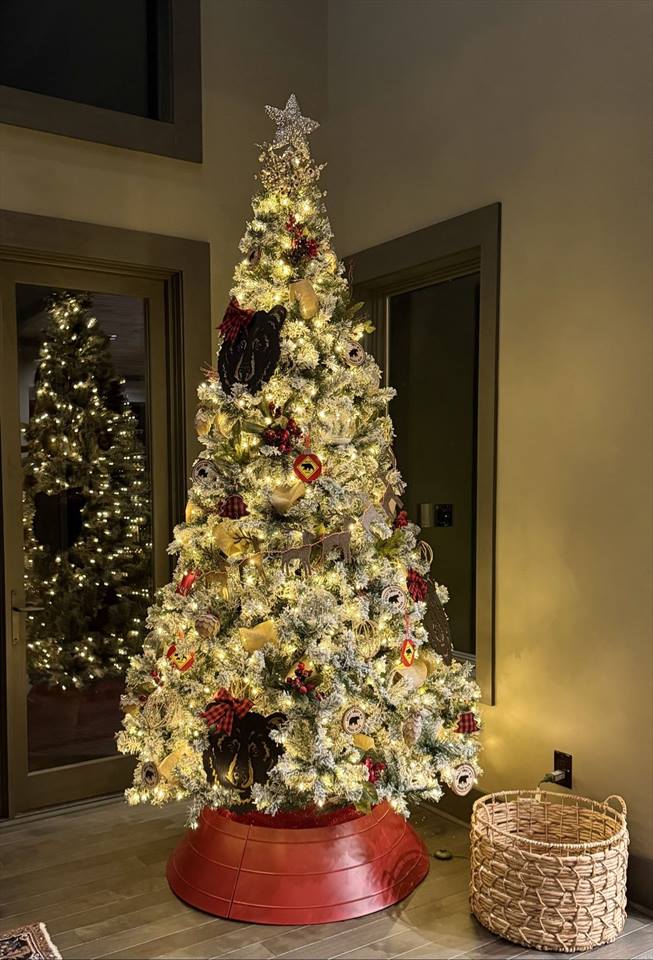 Living room dressed for the holidays with a lit tree decorated with bear ornaments