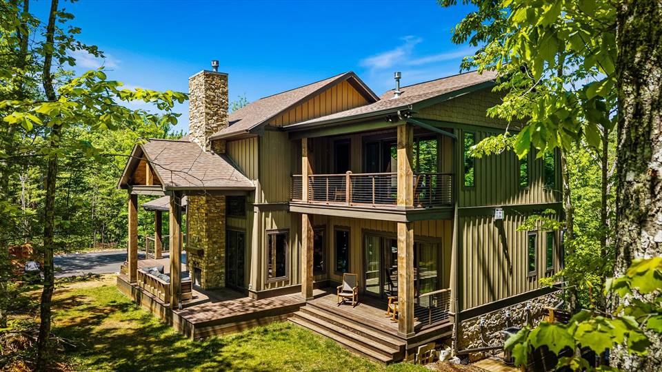 Chalet exterior showing 2 levels of wrap-around decking and cable rails
