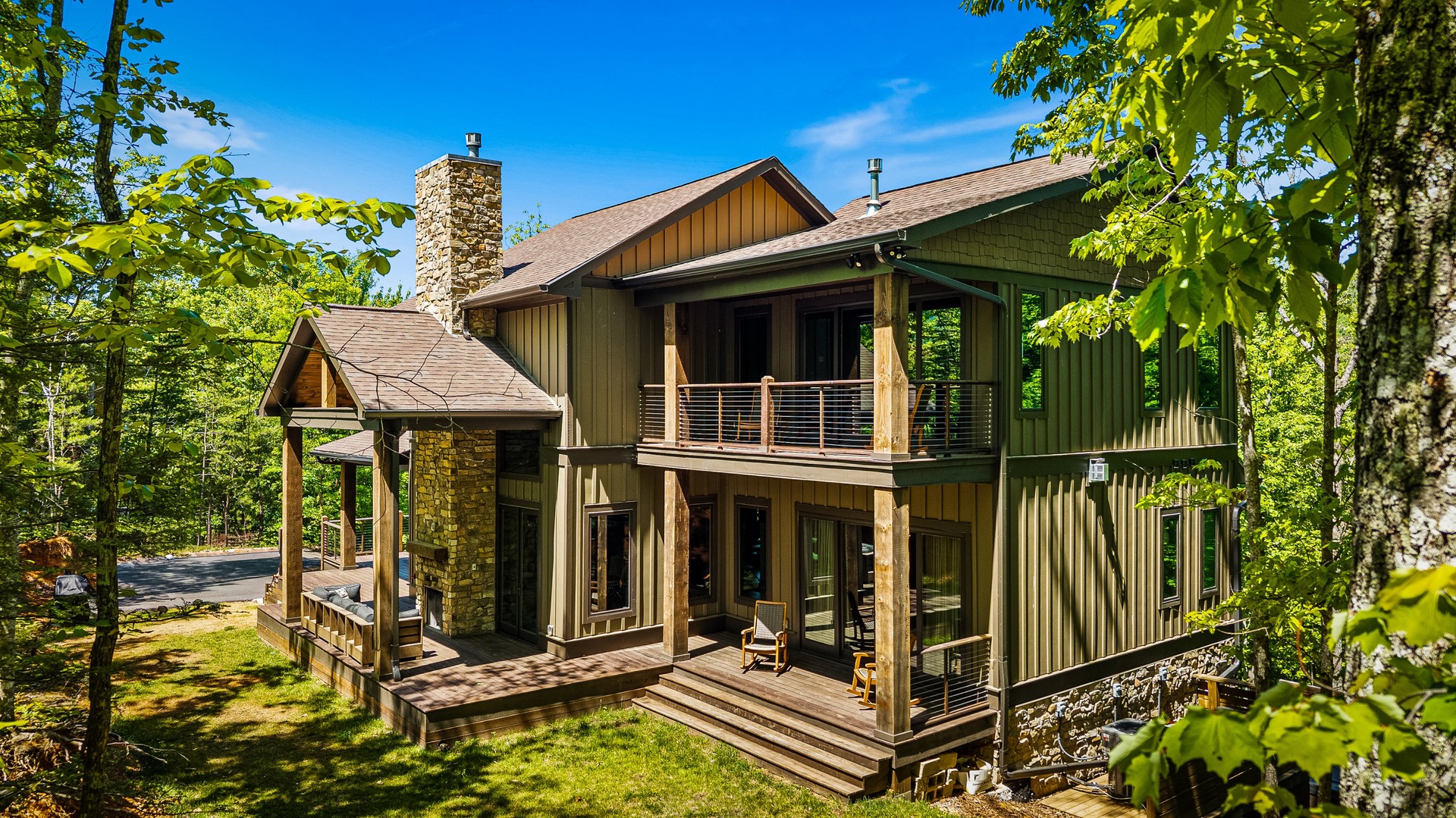 Chalet exterior showing 2 levels of wrap-around decking and cable rails
