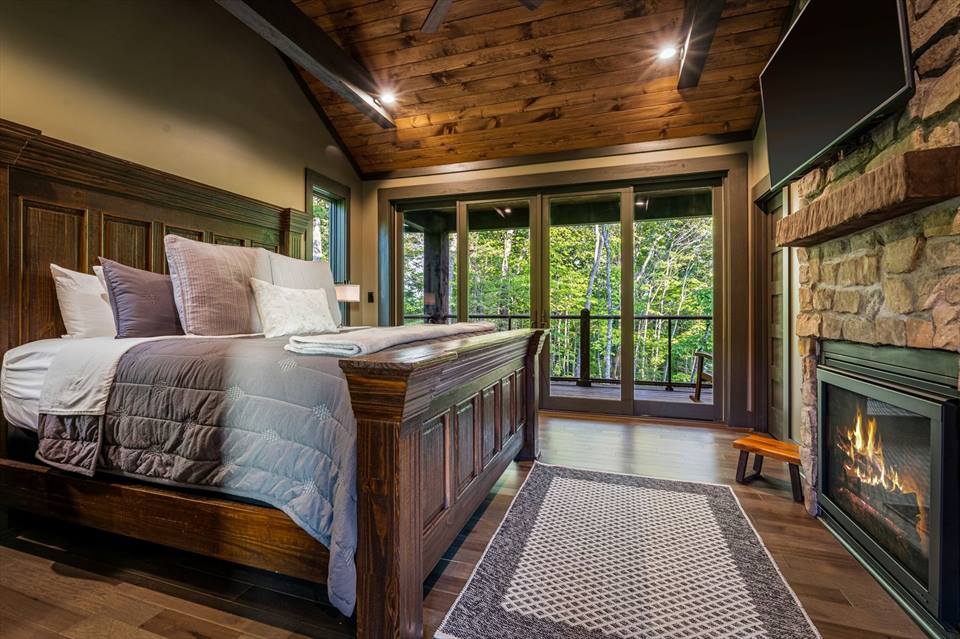 Bedroom 2 with king bed, gas fireplace, custom 9’ barn door, no curtains for amazing views, and doors opening to the private balcony