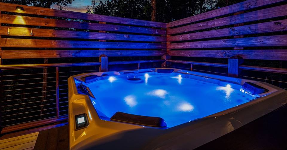 Private 7-seat hot tub glowing beneath the night sky